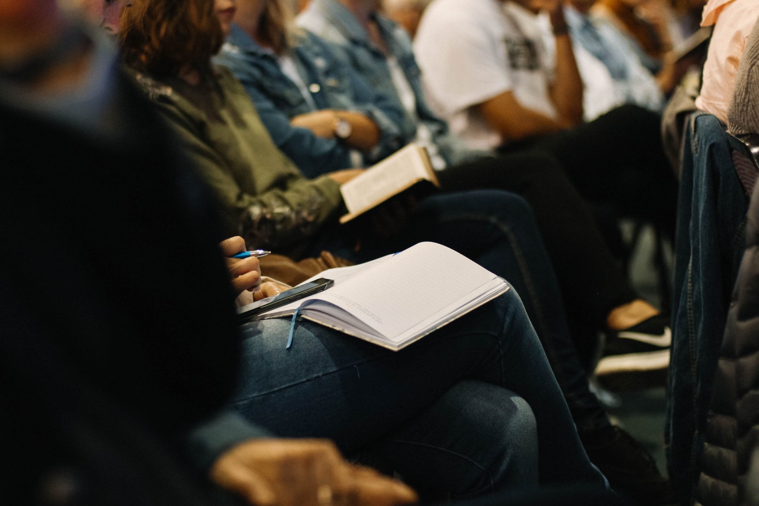 Photo of people taking notes at a conference